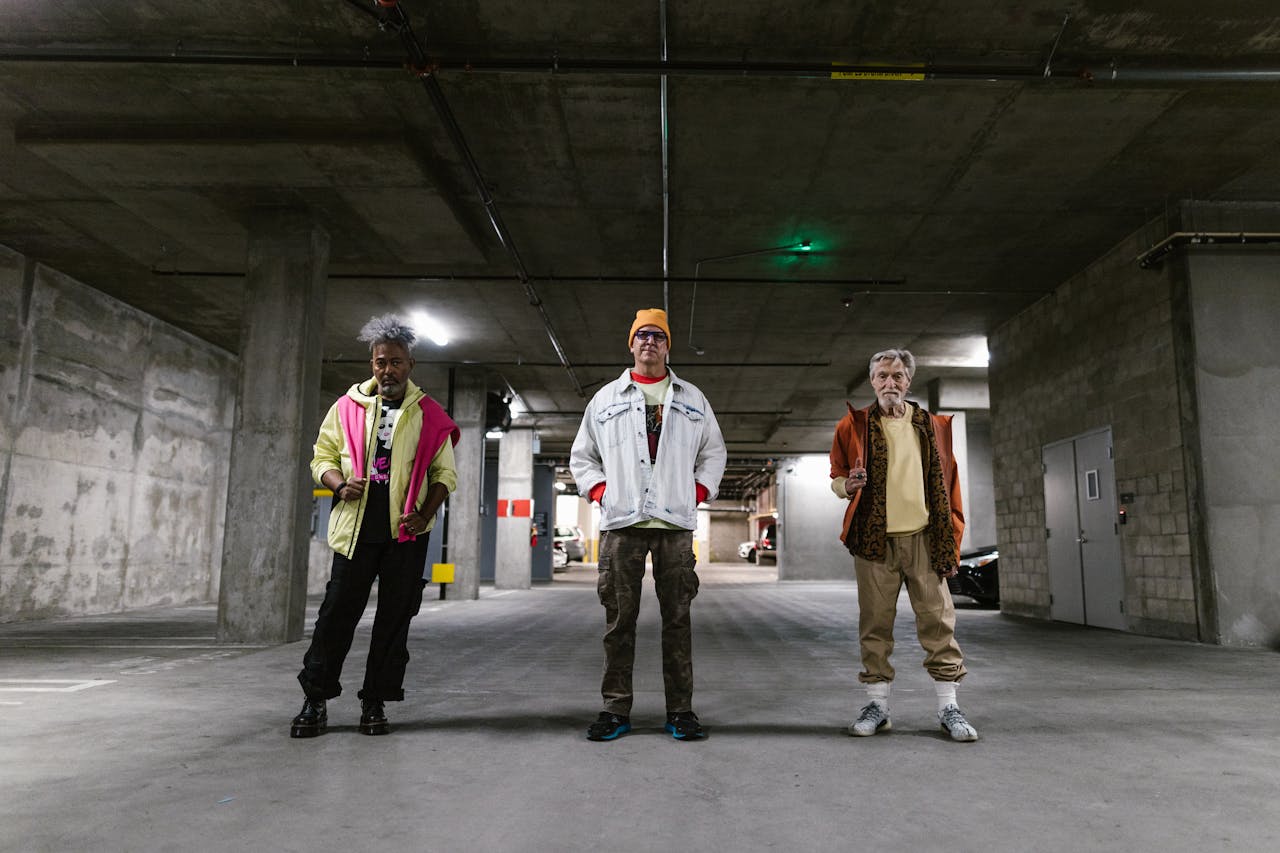 Diverse group of men showcasing street fashion in an urban parking garage. Trendy outfits and distinctive styles.